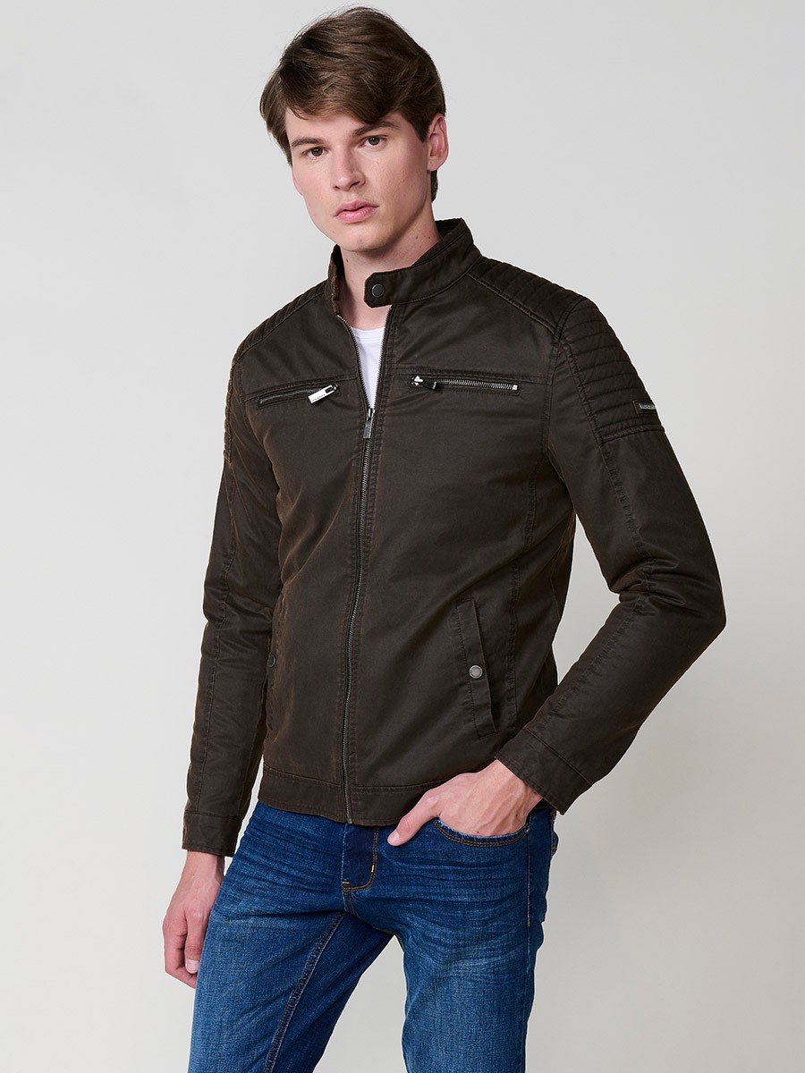 Cazadora marrón de hombre con cuello alto, bolsillos y cierre delantero de cremallera. Tejido 100% poliéster, ligero y resistente.