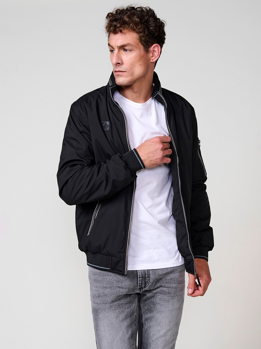 Cazadora de hombre en color negro con cuello alto y cierre delantero con cremallera. Confeccionada en 100% poliéster, cómoda y versátil.