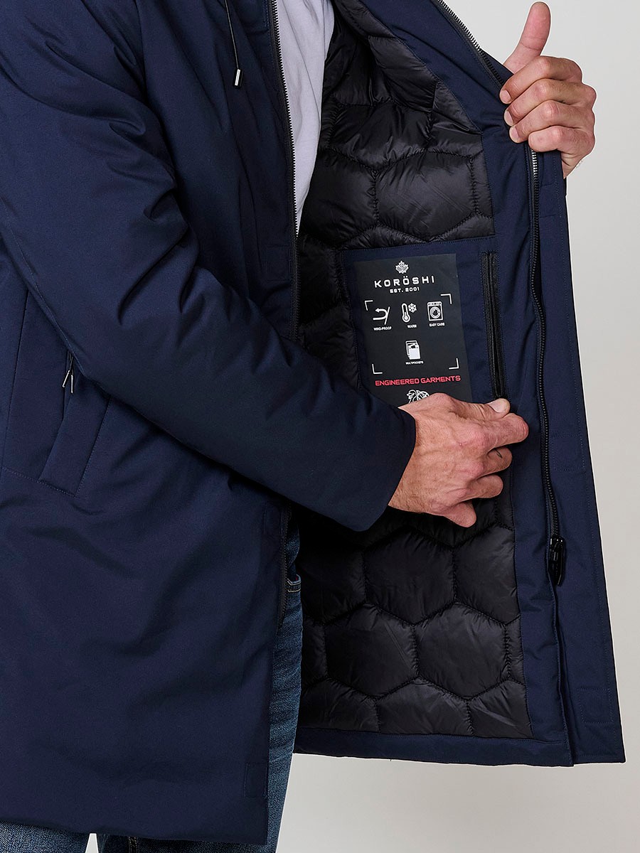 Parka navy de hombre con capucha, bolsillos y cierre delantero de cremallera. Tejido 100% poliéster, resistente y versátil.
