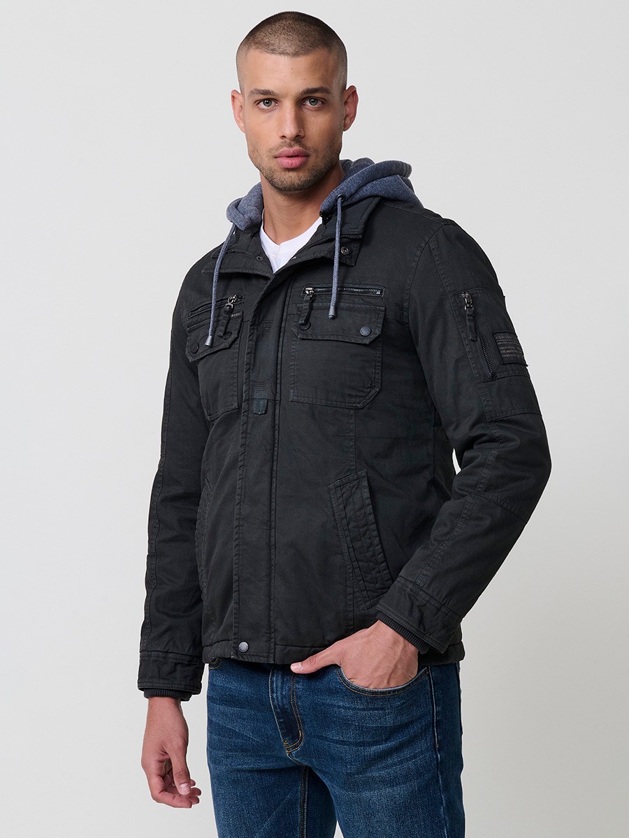 Cazadora negra de hombre con capucha, bolsillos y cierre delantero de cremallera. Confeccionada en 100% algodón resistente y transpirable.
