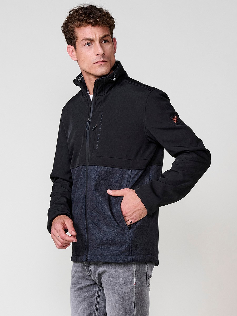 Cazadora negra de hombre con cuello alto, bolsillos y cierre delantero de cremallera. Confeccionada en 100% poliéster resistente y versátil.