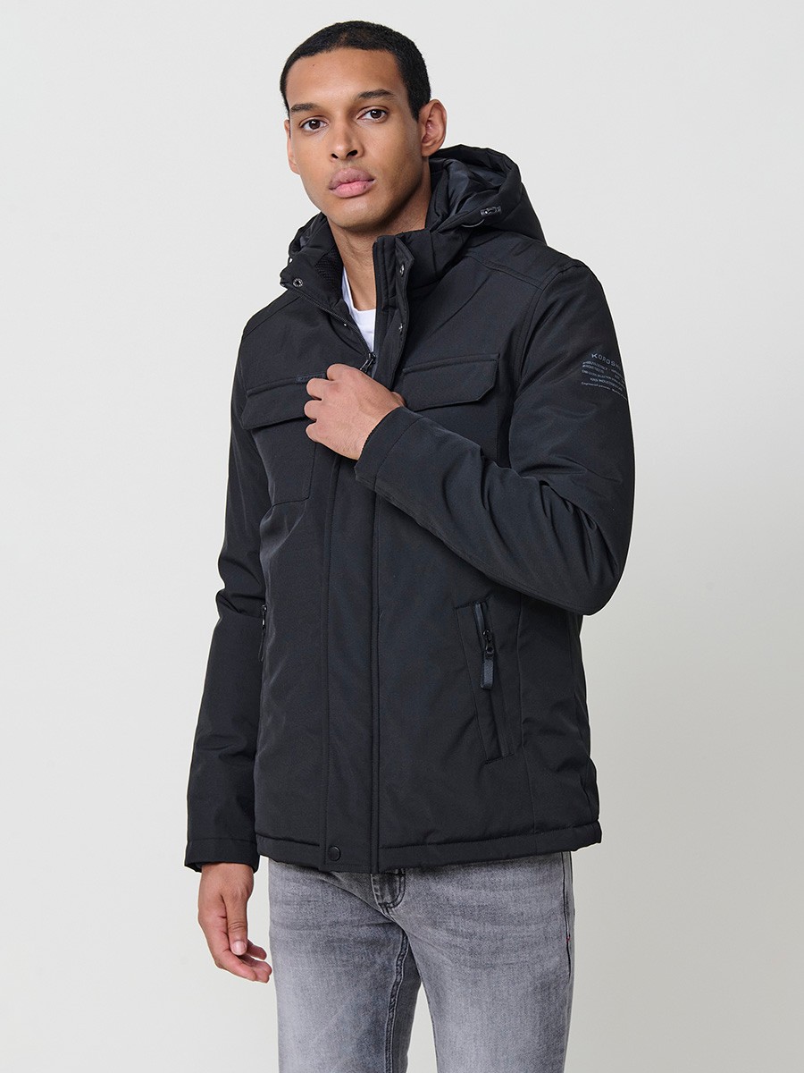 Cazadora acolchada negra de hombre con cuello alto, capucha, bolsillos y cierre delantero de cremallera. Confeccionada en 100% poliéster resistente.