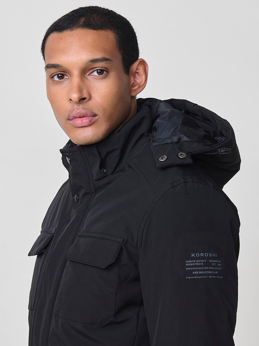Gesteppte Herrenjacke in Schwarz mit hohem Kragen, Kapuze, Reißverschluss und Taschen. Aus 100 % Polyester, warm und strapazierfähig.