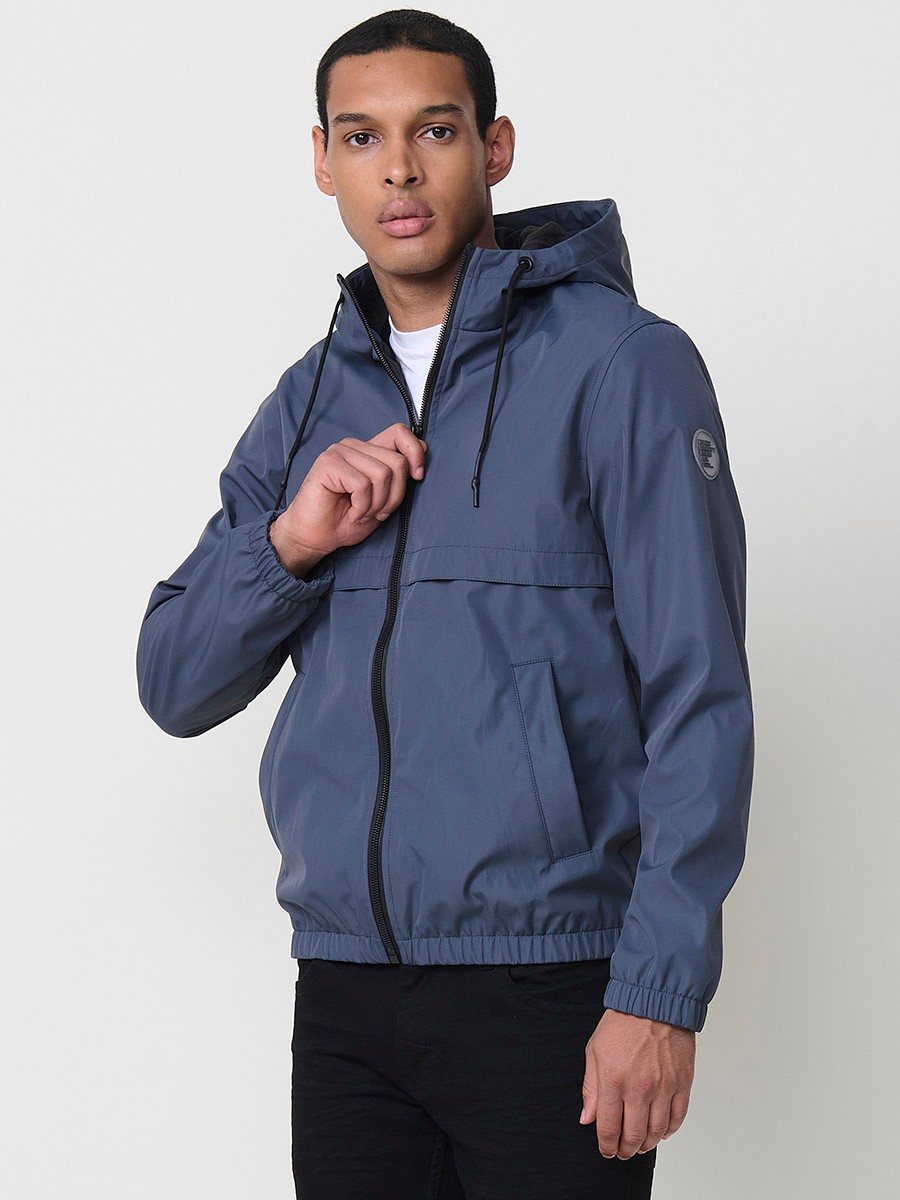 Blaue Herrenjacke mit Kapuze, Reißverschluss und Kunstfellfutter. Aus 100 % Polyester, warm und strapazierfähig.