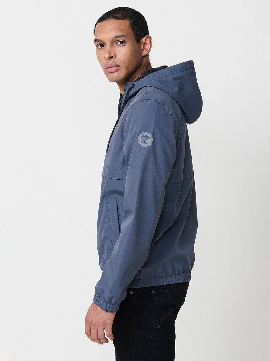 Blaue Herrenjacke mit Kapuze, Reißverschluss und Kunstfellfutter. Aus 100 % Polyester, warm und strapazierfähig.