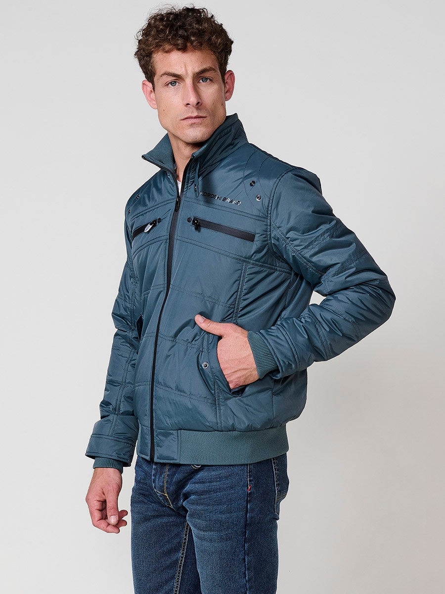 Gesteppte Herrenjacke in Blau mit hohem Kragen, Reißverschluss und Taschen. Aus 100 % Polyester, warm und strapazierfähig.