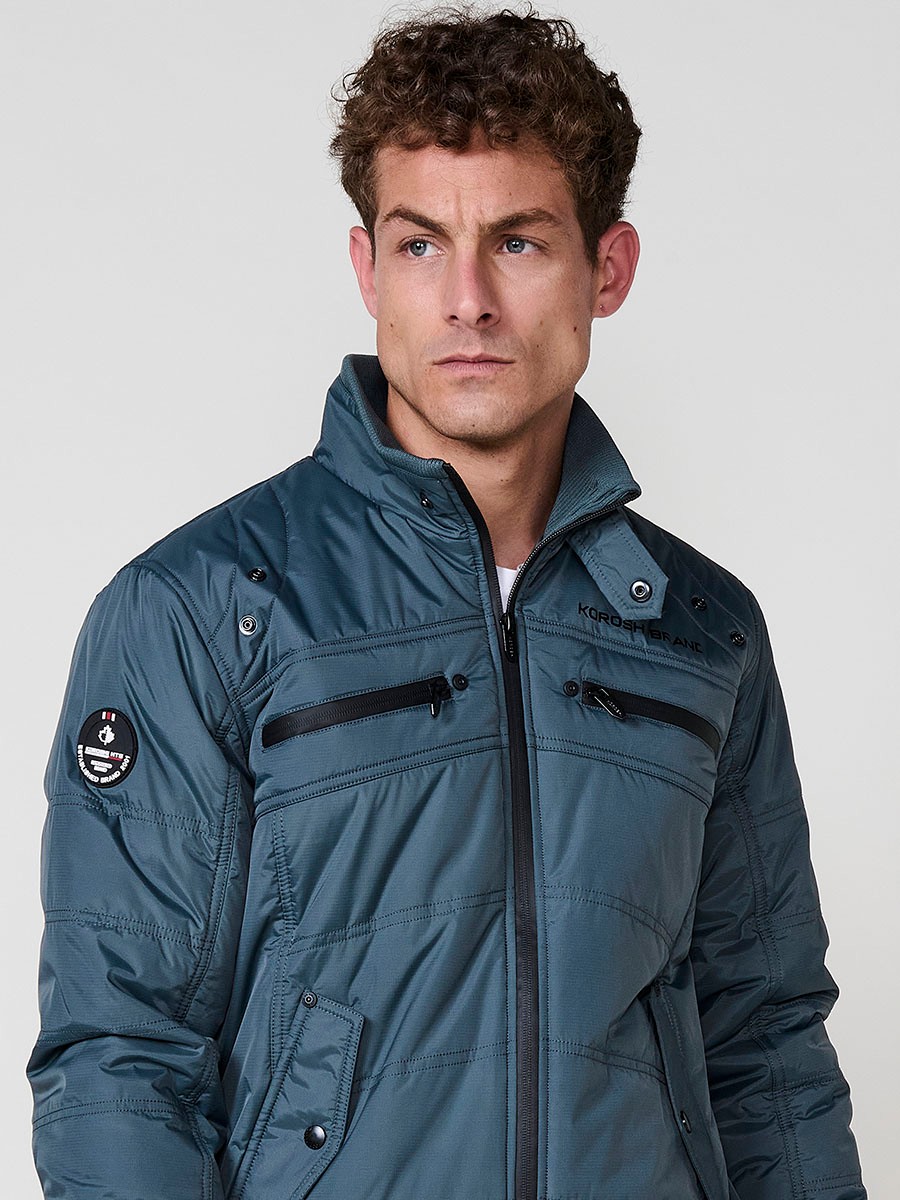 Gesteppte Herrenjacke in Blau mit hohem Kragen, Reißverschluss und Taschen. Aus 100 % Polyester, warm und strapazierfähig.