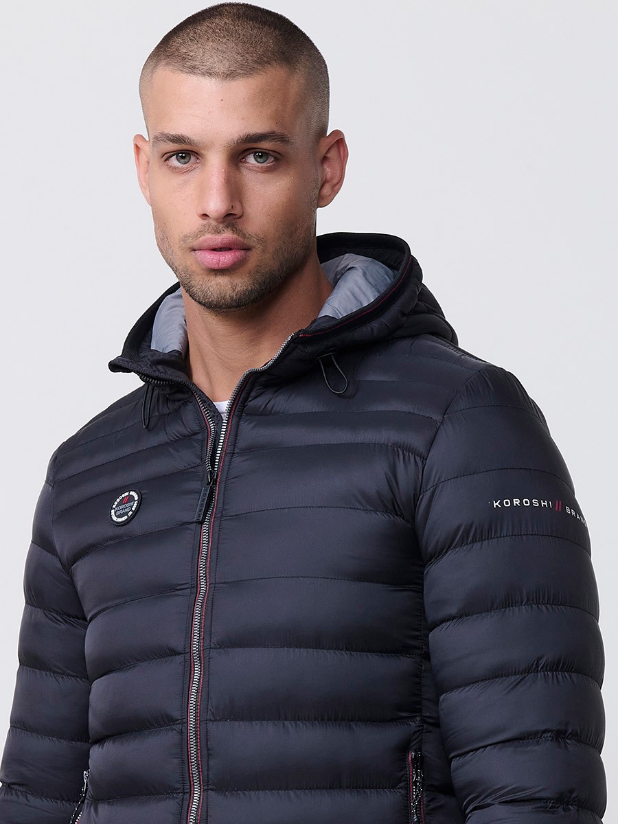 Gesteppte schwarze Herrenjacke mit hohem Kragen, Kapuze, Reißverschluss und Taschen. Aus 100 % Polyester, warm und strapazierfähig.