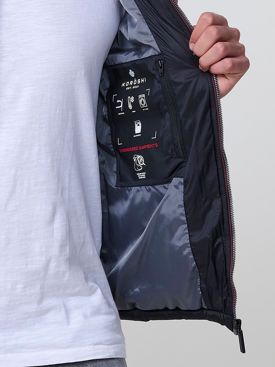 Gesteppte schwarze Herrenjacke mit hohem Kragen, Kapuze, Reißverschluss und Taschen. Aus 100 % Polyester, warm und strapazierfähig.
