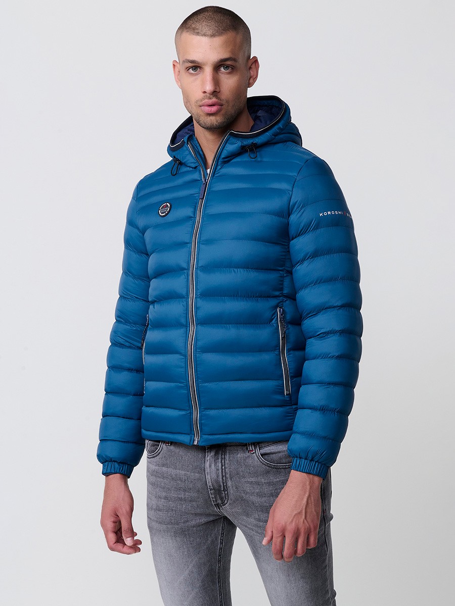 Gesteppte blaue Herrenjacke mit hohem Kragen, Kapuze, Reißverschluss und Taschen. Aus 100 % Polyester, warm und strapazierfähig.