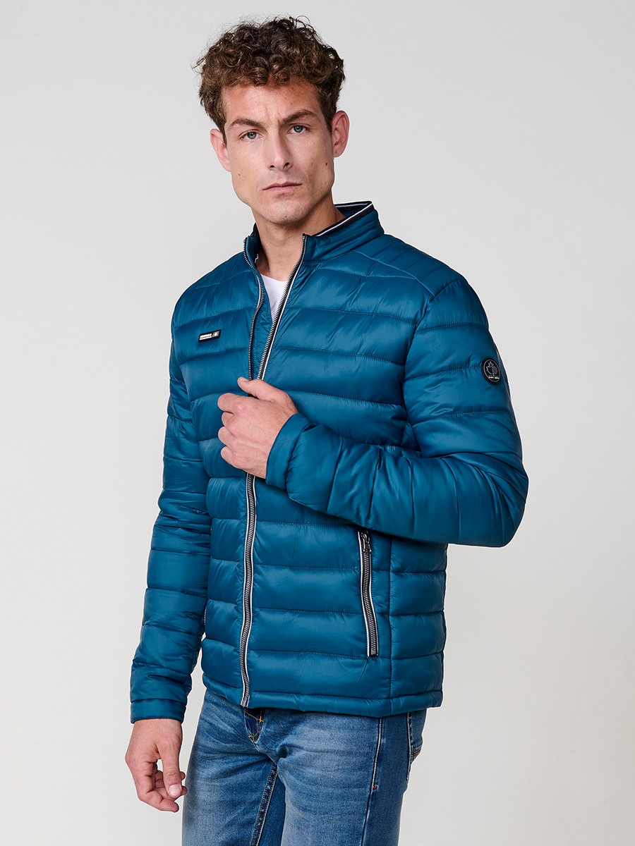 Cazadora acolchada de hombre en color azul, con cuello redondo alto y cierre delantero de cremallera. Confeccionada en 100% poliamida.