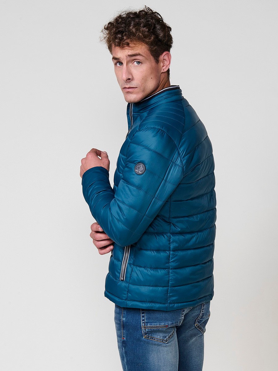 Cazadora acolchada de hombre en color azul, con cuello redondo alto y cierre delantero de cremallera. Confeccionada en 100% poliamida.