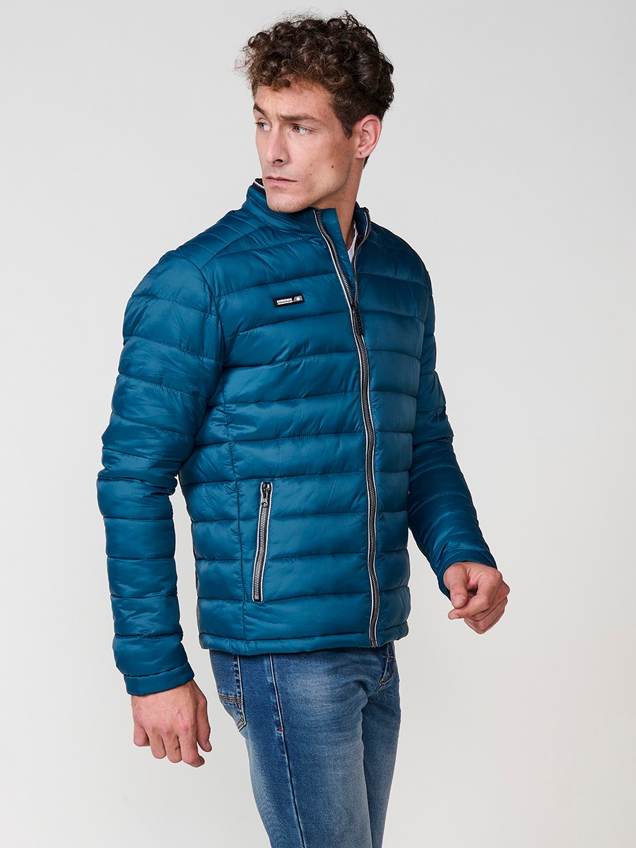 Cazadora acolchada de hombre en color azul, con cuello redondo alto y cierre delantero de cremallera. Confeccionada en 100% poliamida.