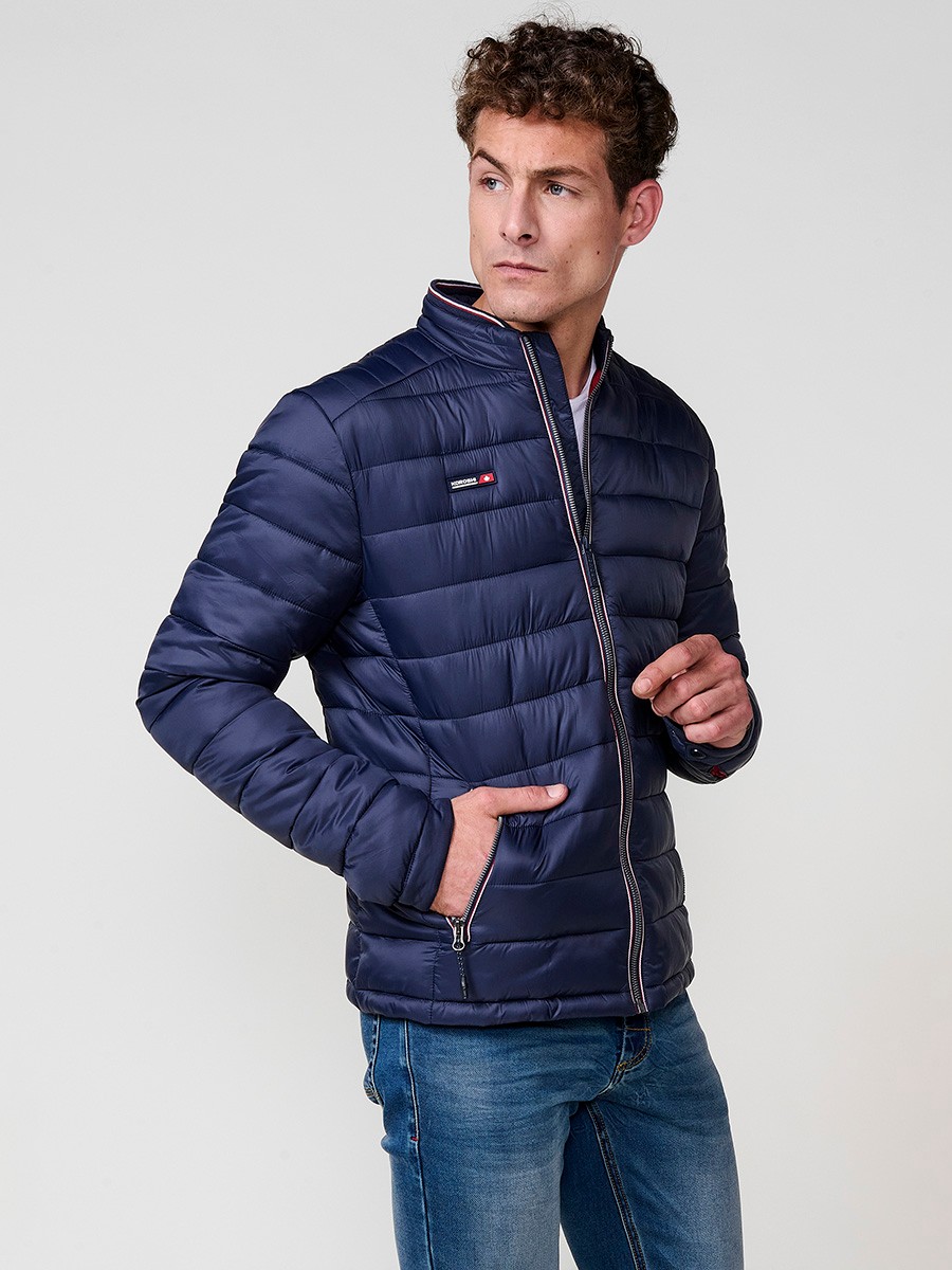 Cazadora acolchada de hombre en color navy, con cuello redondo alto y cierre delantero de cremallera. Confeccionada en 100% poliamida.