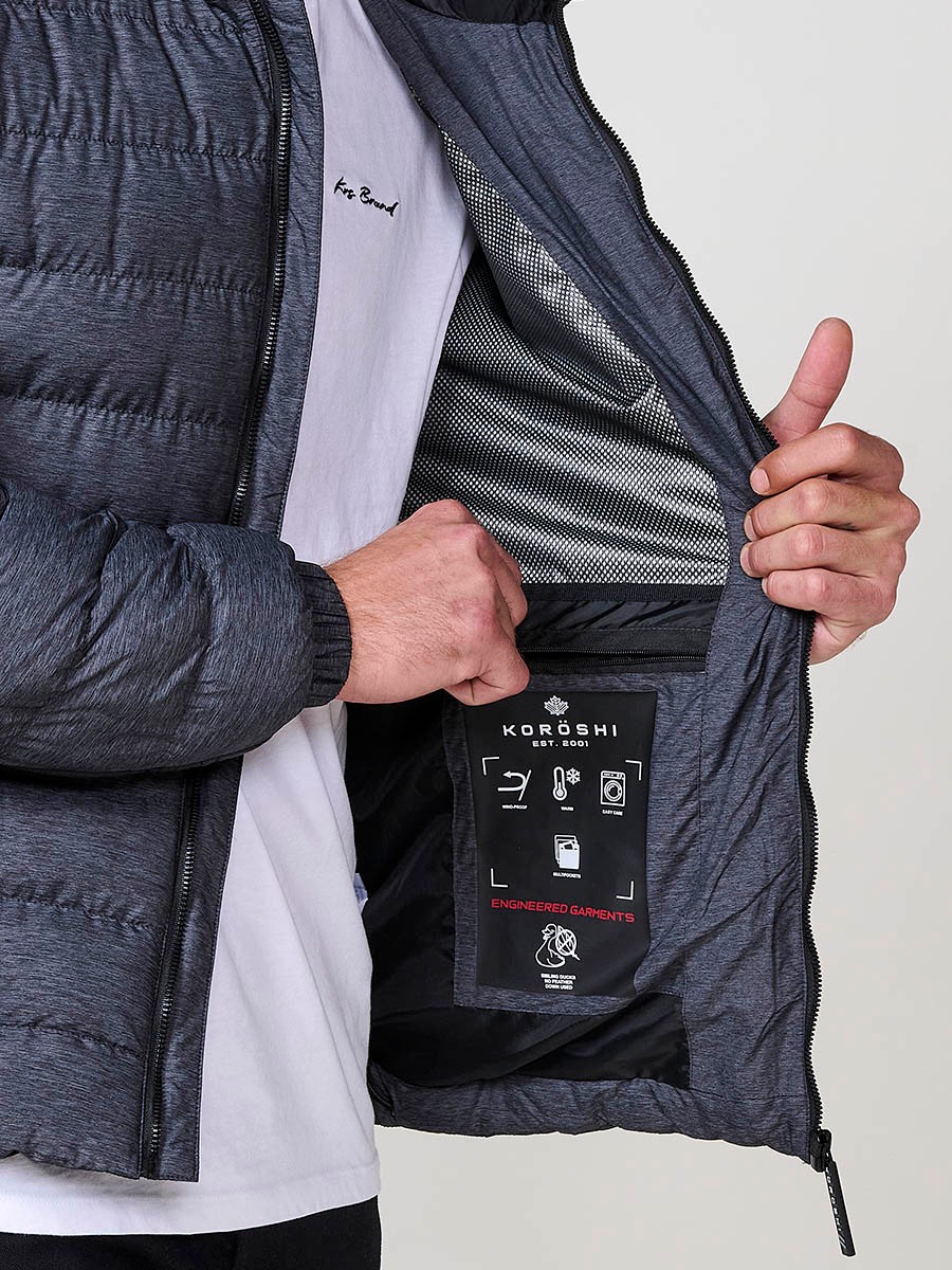 Gesteppte graue Herrenjacke mit hohem Kragen, Kapuze, Reißverschluss und Taschen. Aus 100 % Polyester, warm und strapazierfähig.