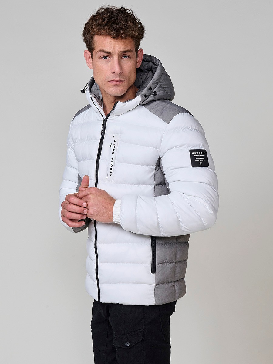 Gesteppte ecrufarbene Herrenjacke mit hohem Kragen, Kapuze, Reißverschluss und Taschen. Aus 100 % Polyester, warm und strapazierfähig.