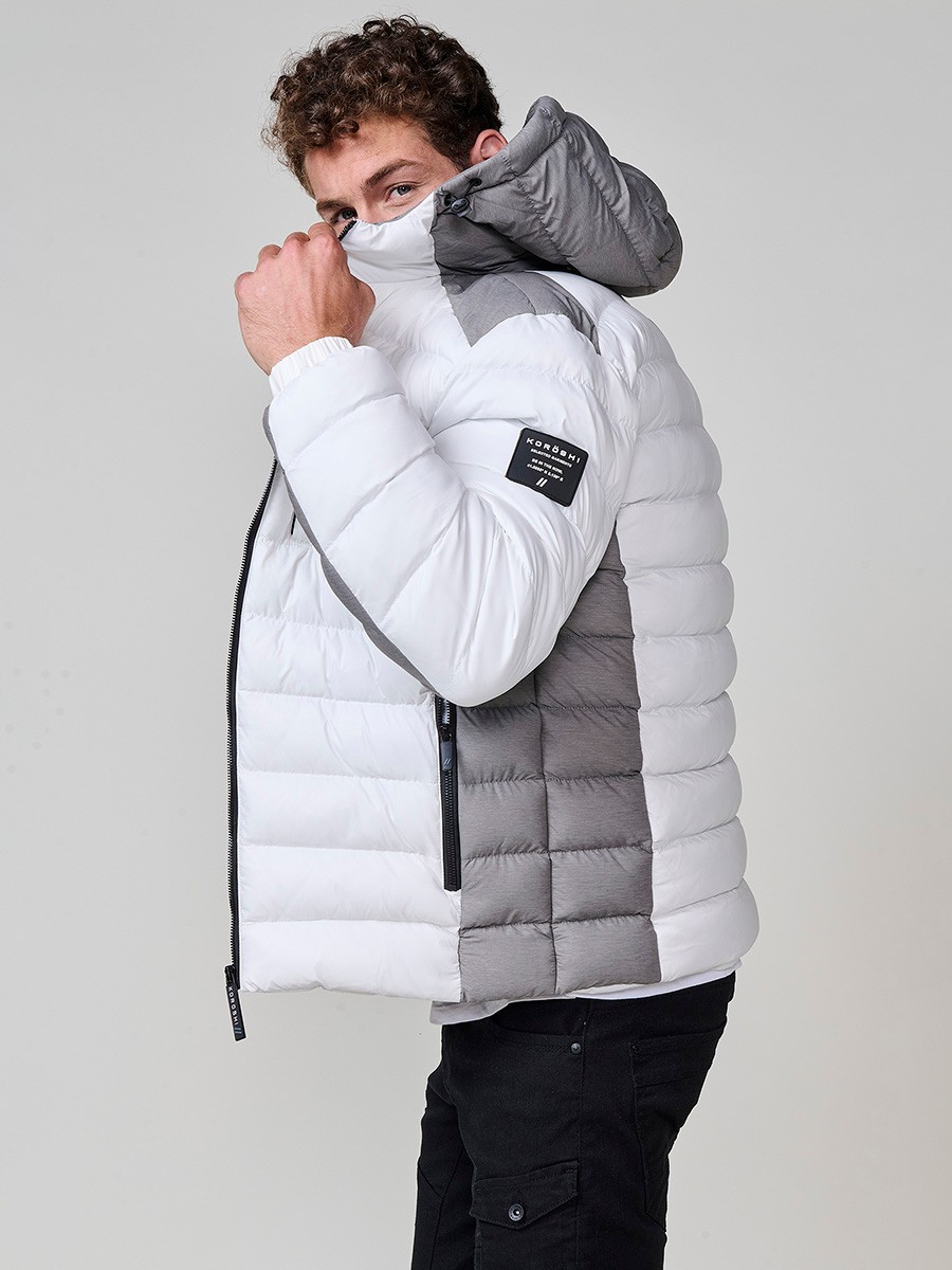 Gesteppte ecrufarbene Herrenjacke mit hohem Kragen, Kapuze, Reißverschluss und Taschen. Aus 100 % Polyester, warm und strapazierfähig.