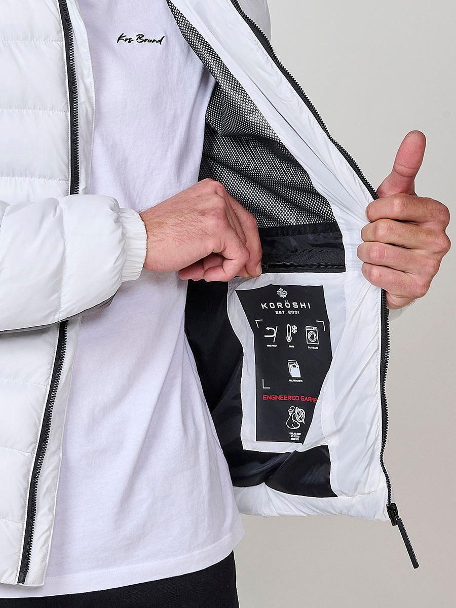 Gesteppte ecrufarbene Herrenjacke mit hohem Kragen, Kapuze, Reißverschluss und Taschen. Aus 100 % Polyester, warm und strapazierfähig.