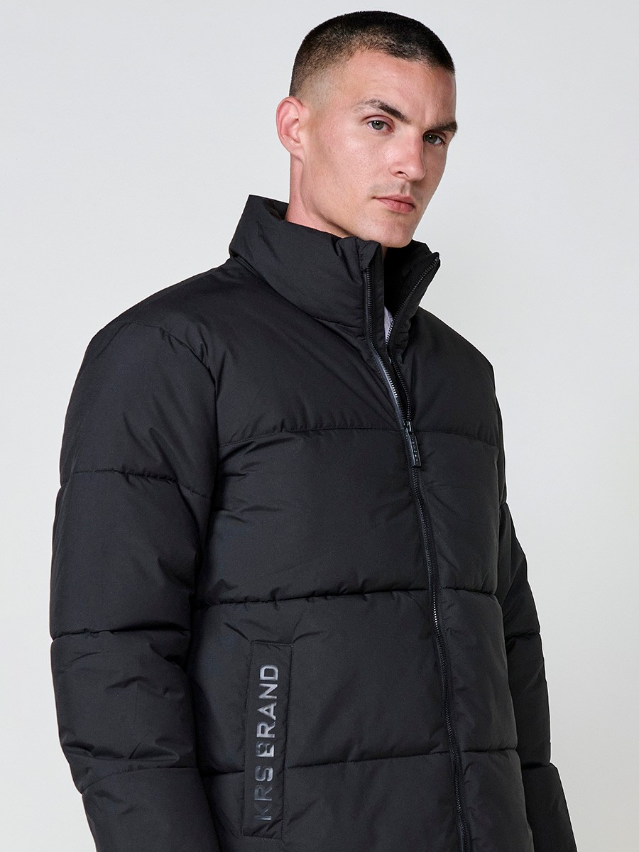Gesteppte schwarze Herrenjacke mit hohem Kragen, Reißverschluss und Taschen. Aus 100 % Polyester, warm und strapazierfähig.