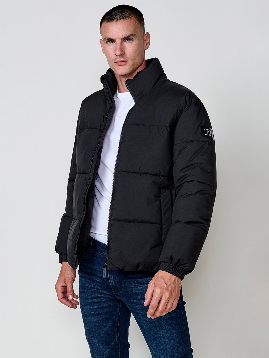 Gesteppte schwarze Herrenjacke mit hohem Kragen, Reißverschluss und Taschen. Aus 100 % Polyester, warm und strapazierfähig.