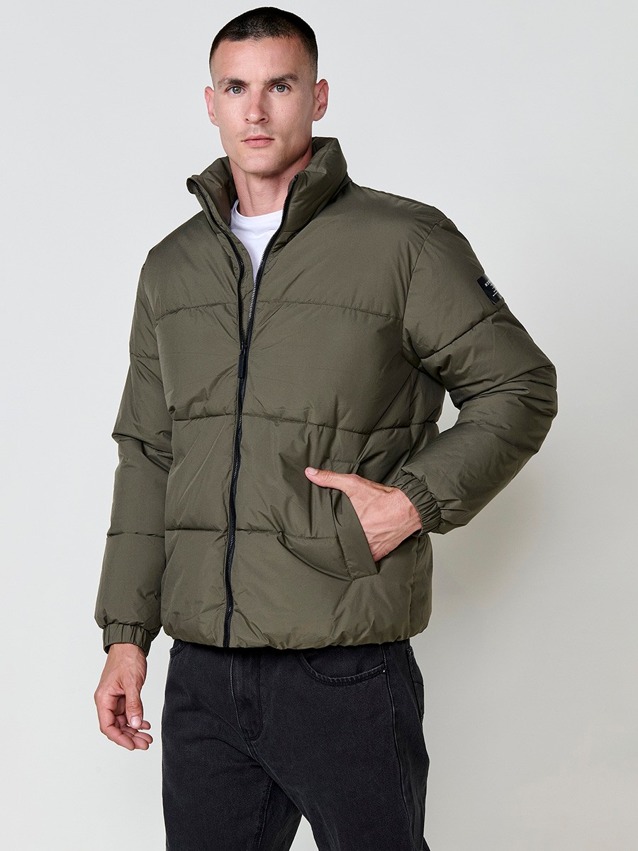 Gesteppte khakifarbene Herrenjacke mit hohem Kragen, Reißverschluss und Taschen. Aus 100 % Polyester, warm und strapazierfähig.