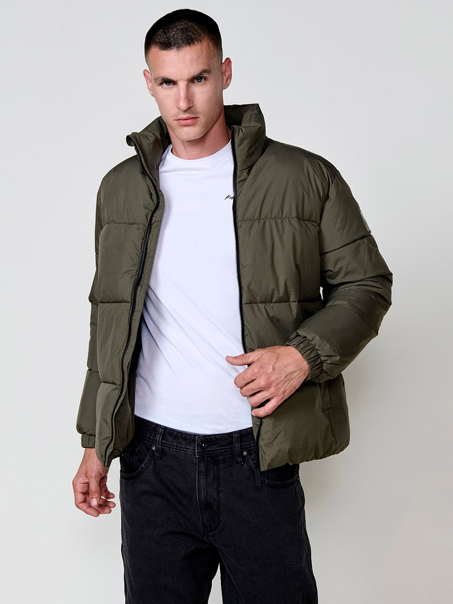 Gesteppte khakifarbene Herrenjacke mit hohem Kragen, Reißverschluss und Taschen. Aus 100 % Polyester, warm und strapazierfähig.