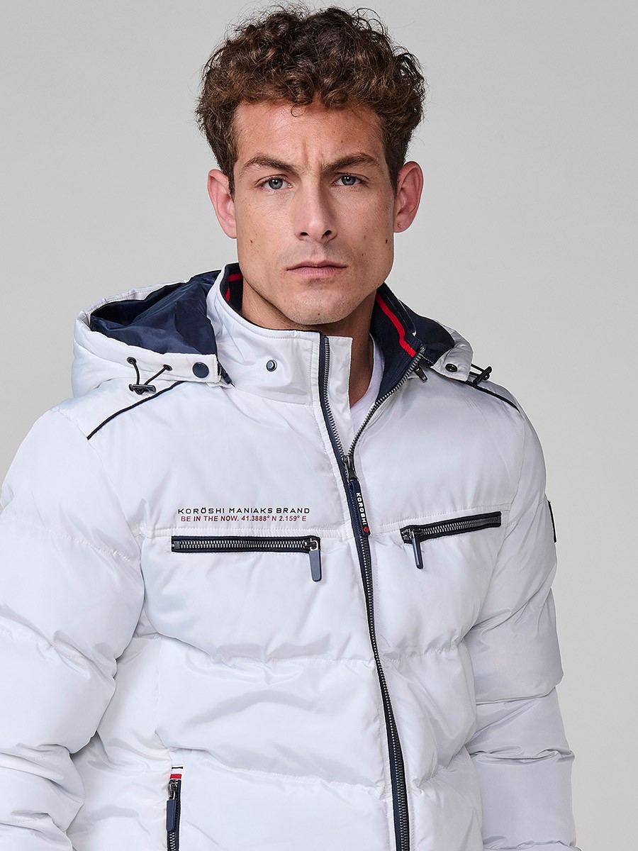 Gesteppte ecrufarbene Herrenjacke mit hohem Kragen, Kapuze, Reißverschluss und Taschen. Aus 100 % Polyester, warm und strapazierfähig.