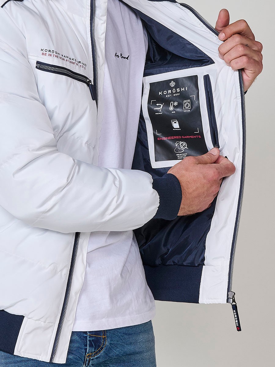Gesteppte ecrufarbene Herrenjacke mit hohem Kragen, Kapuze, Reißverschluss und Taschen. Aus 100 % Polyester, warm und strapazierfähig.