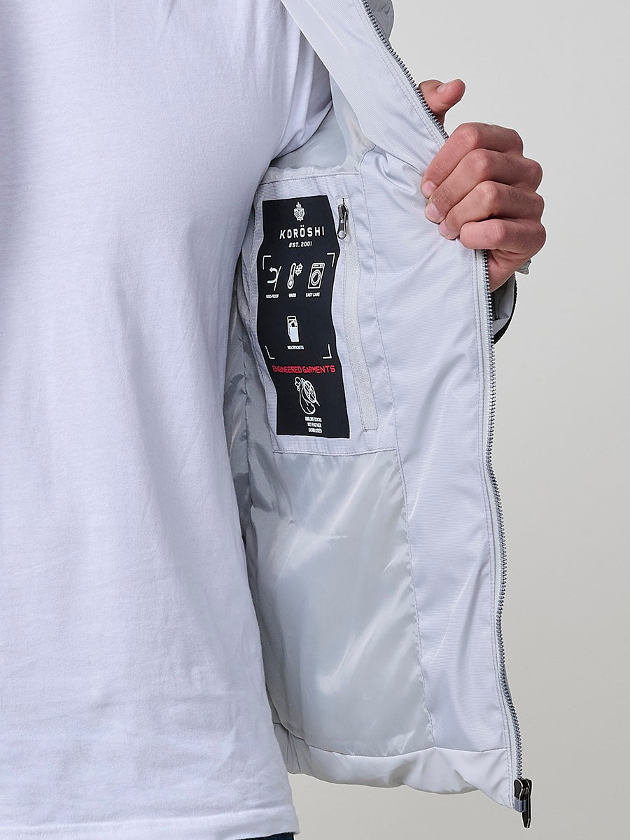 Gesteppte perlgraue Herrenjacke mit hohem Kragen, Kapuze, Reißverschluss und Taschen. Aus 100 % Polyester, warm und strapazierfähig.