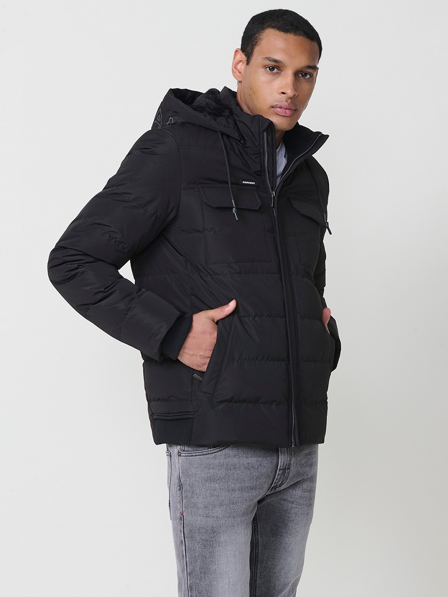 Gesteppte schwarze Herrenjacke mit hohem Kragen, Kapuze, Reißverschluss und Taschen. Aus 100 % Polyester, warm und strapazierfähig.