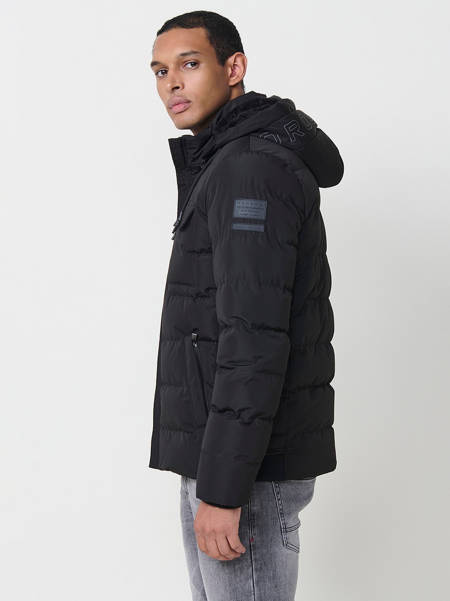 Gesteppte schwarze Herrenjacke mit hohem Kragen, Kapuze, Reißverschluss und Taschen. Aus 100 % Polyester, warm und strapazierfähig.