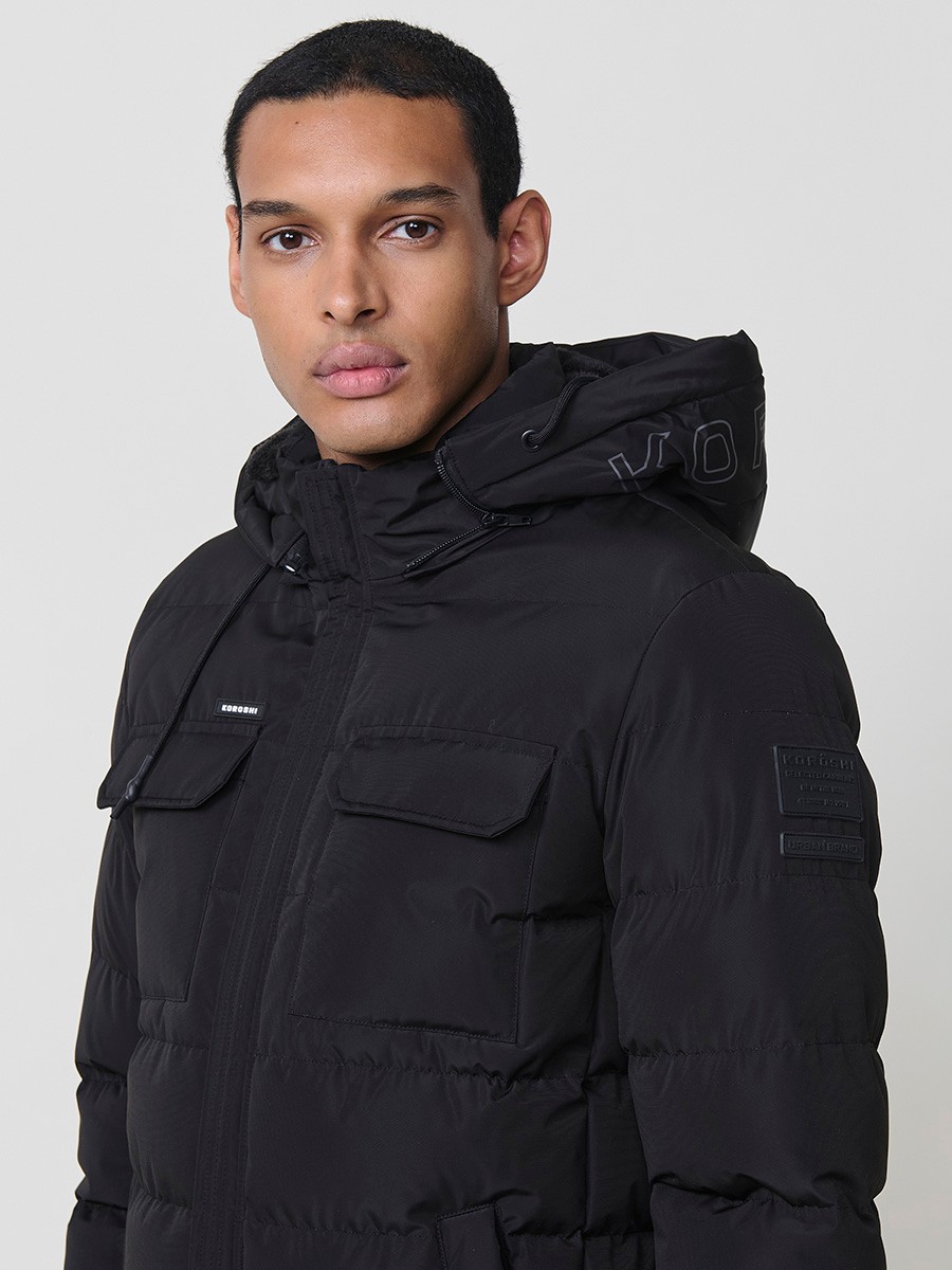 Gesteppte schwarze Herrenjacke mit hohem Kragen, Kapuze, Reißverschluss und Taschen. Aus 100 % Polyester, warm und strapazierfähig.