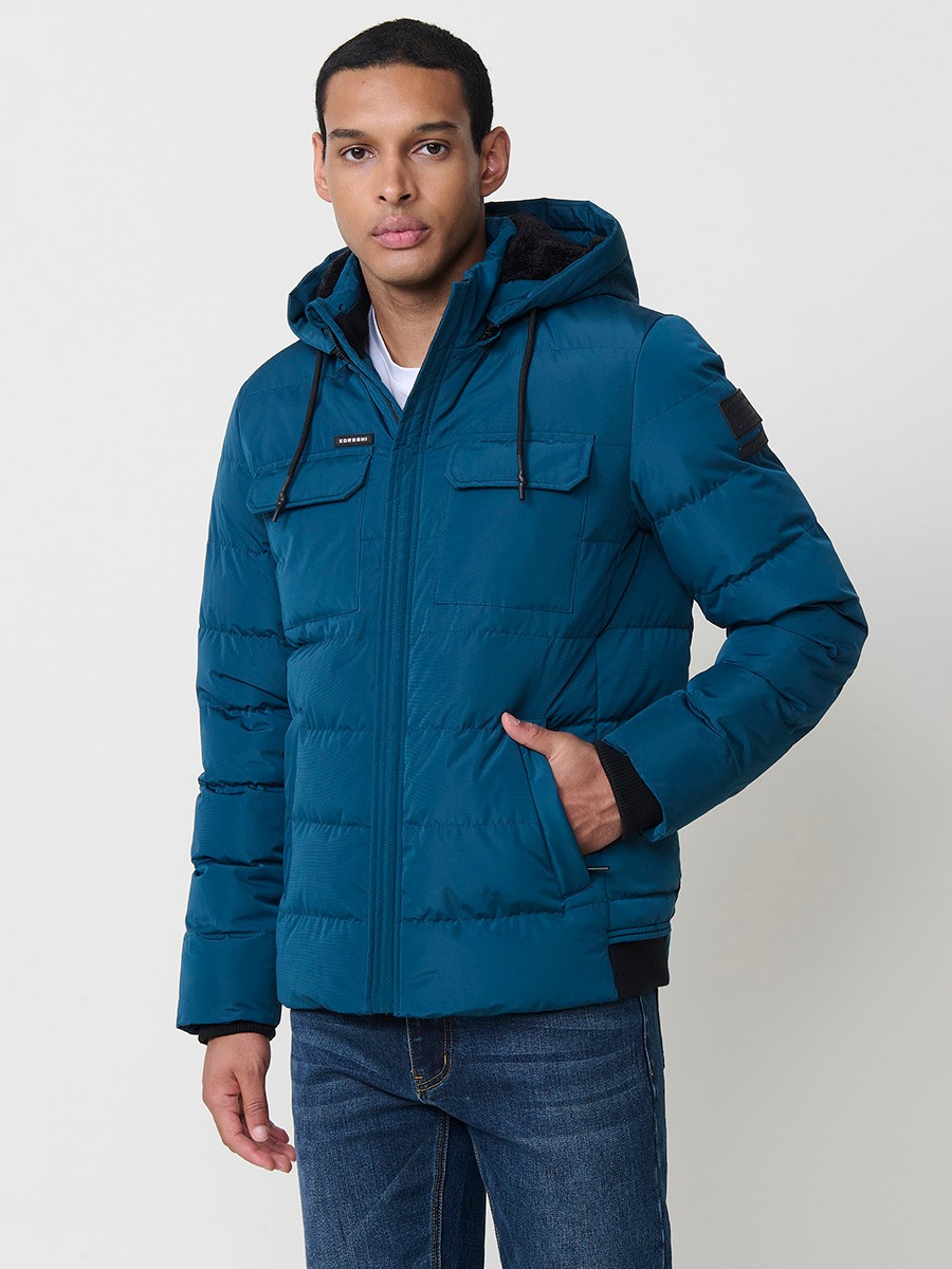 Gesteppte blaue Herrenjacke mit hohem Kragen, Kapuze, Reißverschluss und Taschen. Aus 100 % Polyester, warm und strapazierfähig.