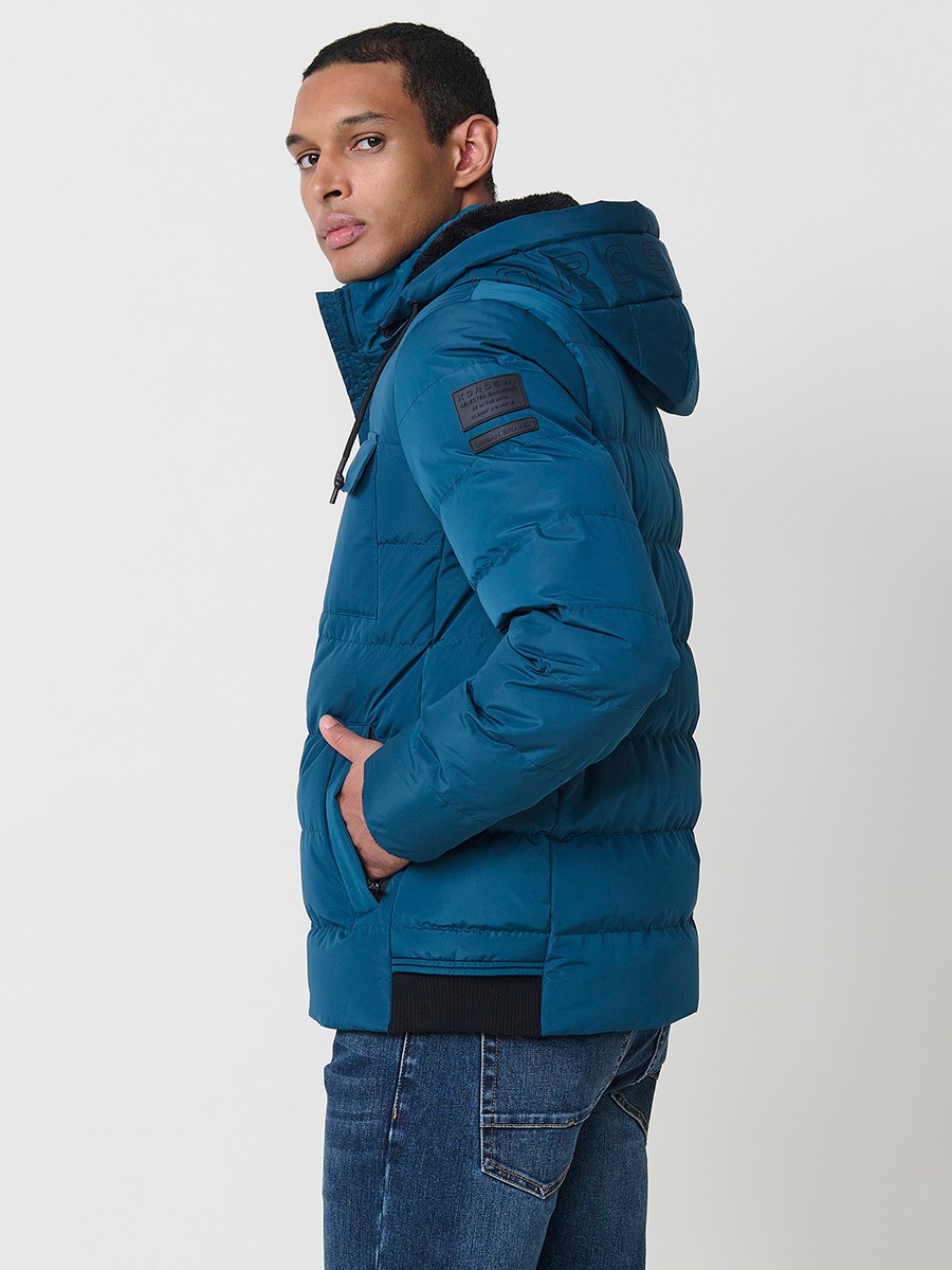 Gesteppte blaue Herrenjacke mit hohem Kragen, Kapuze, Reißverschluss und Taschen. Aus 100 % Polyester, warm und strapazierfähig.