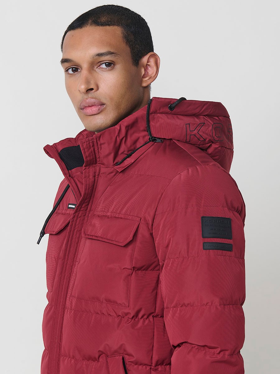 Gesteppte weinrote Herrenjacke mit hohem Kragen, Kapuze, Reißverschluss und Taschen. Aus 100 % Polyester, warm und strapazierfähig.