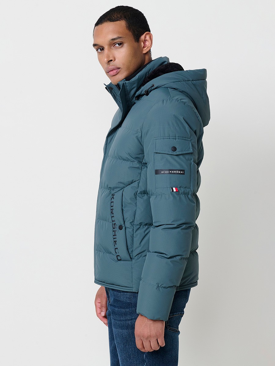 Gesteppte blaue Herrenjacke mit hohem Kragen, Kapuze, Reißverschluss und Taschen. Aus 100 % Polyester, warm und strapazierfähig.