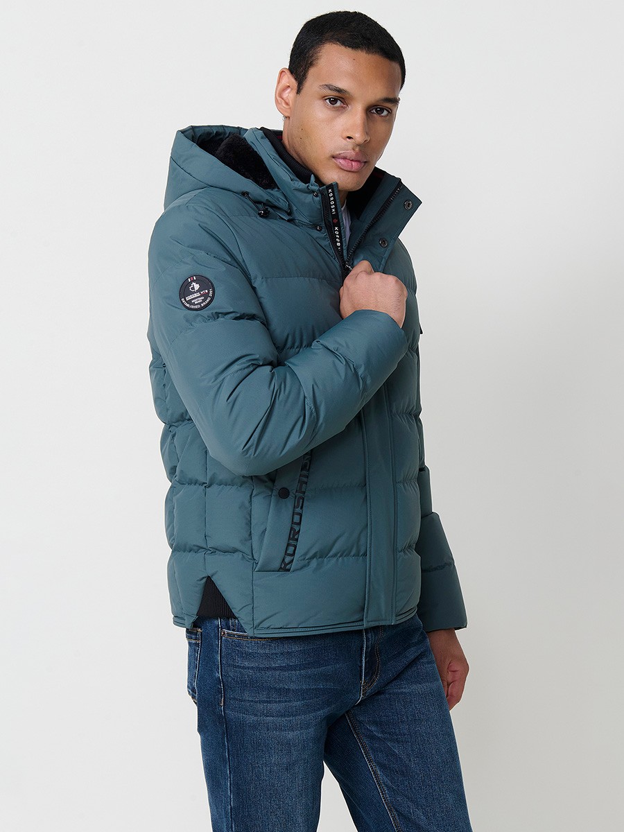 Gesteppte blaue Herrenjacke mit hohem Kragen, Kapuze, Reißverschluss und Taschen. Aus 100 % Polyester, warm und strapazierfähig.