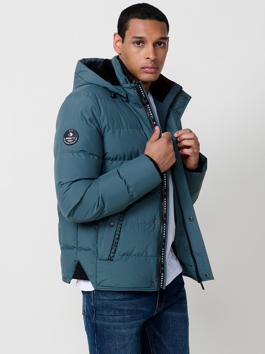 Gesteppte blaue Herrenjacke mit hohem Kragen, Kapuze, Reißverschluss und Taschen. Aus 100 % Polyester, warm und strapazierfähig.