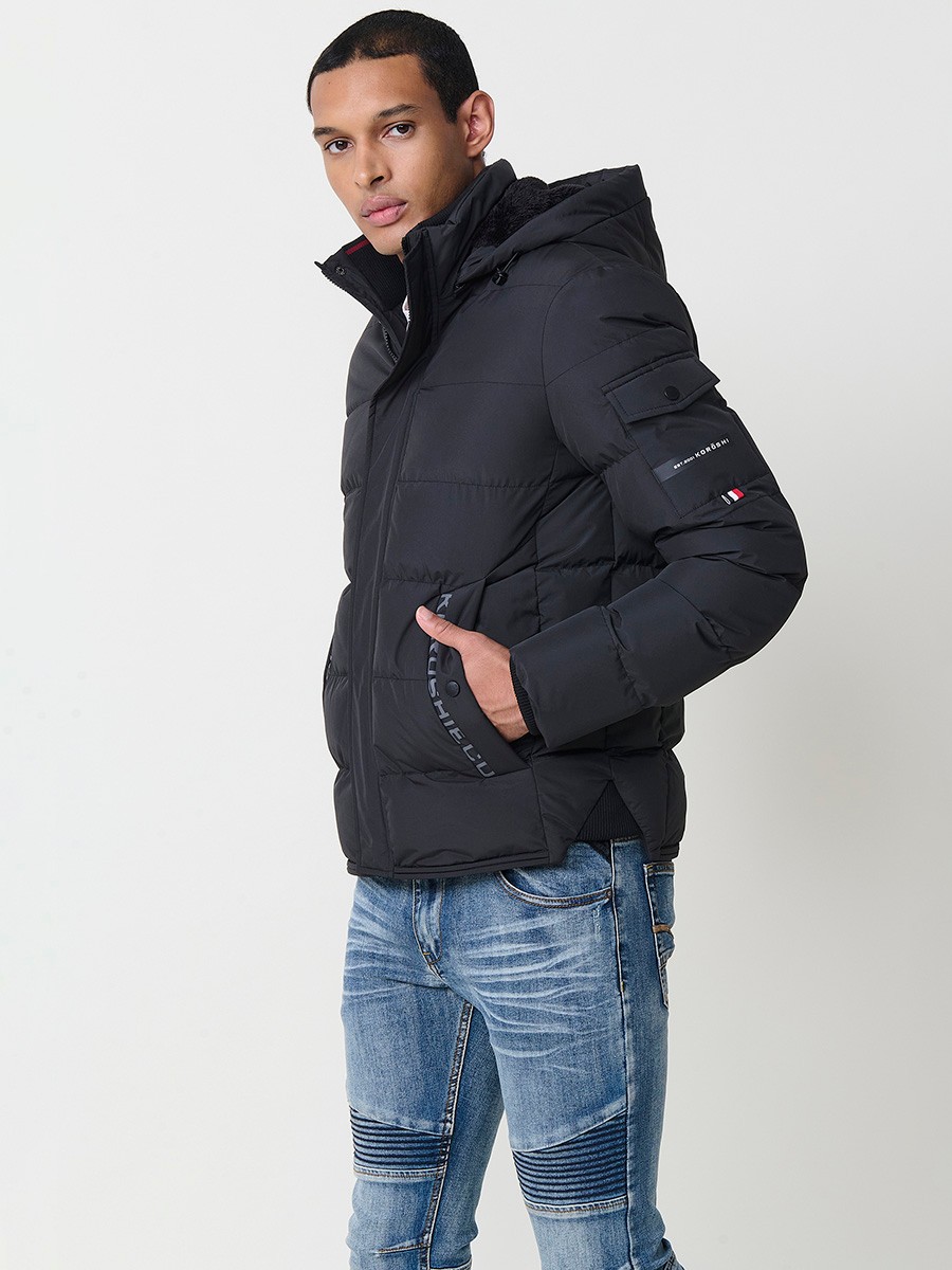 Gesteppte anthrazitfarbene Herrenjacke mit hohem Kragen, Kapuze, Reißverschluss und Taschen. Aus 100 % Polyester, warm und strapazierfähig.