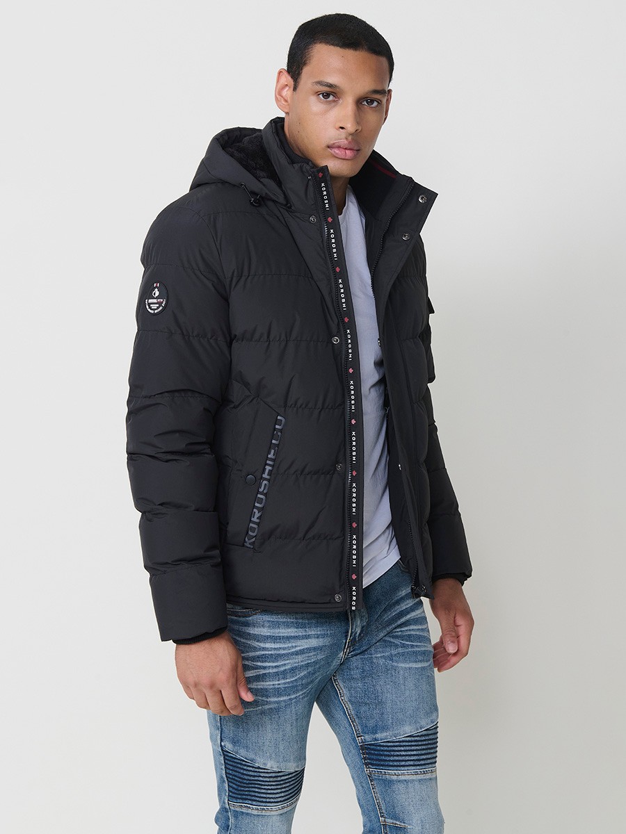 Gesteppte anthrazitfarbene Herrenjacke mit hohem Kragen, Kapuze, Reißverschluss und Taschen. Aus 100 % Polyester, warm und strapazierfähig.