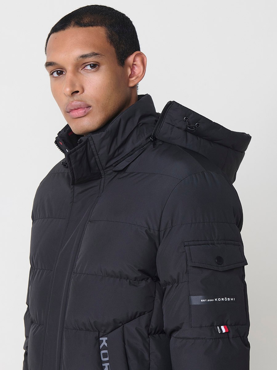 Gesteppte anthrazitfarbene Herrenjacke mit hohem Kragen, Kapuze, Reißverschluss und Taschen. Aus 100 % Polyester, warm und strapazierfähig.
