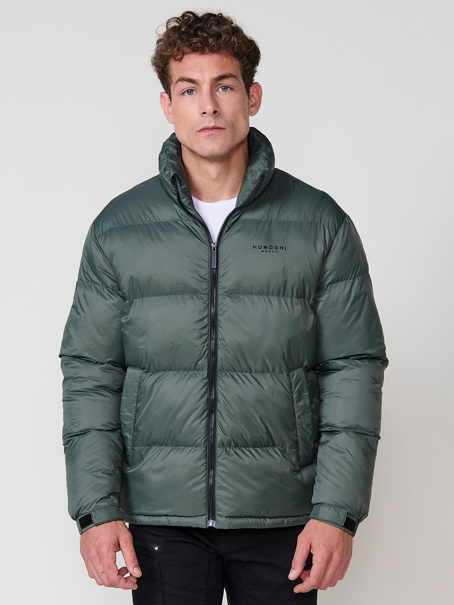 Gesteppte grüne Herrenjacke mit hohem Kragen und Frontreißverschluss. Aus 100 % Polyamid, leicht, strapazierfähig und warm.