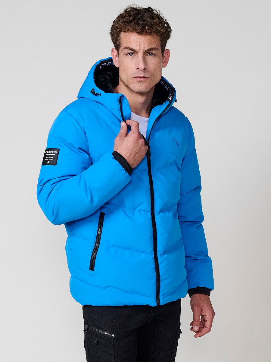 Gesteppte hellblaue Herrenjacke mit hohem Kragen, Kapuze, Reißverschluss und Taschen. Aus 100 % Polyester, warm, strapazierfähig und modern.