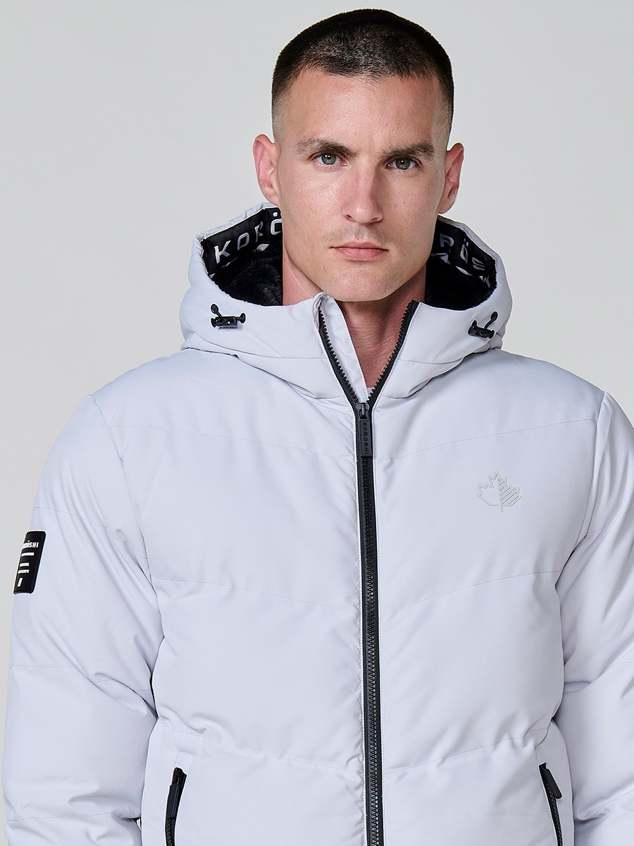 Gesteppte perlgraue Herrenjacke mit hohem Kragen, Kapuze, Reißverschluss und Taschen. Aus 100 % Polyester, warm, leicht und strapazierfähig.