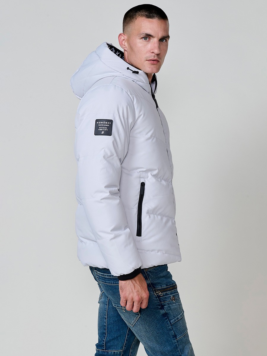 Gesteppte perlgraue Herrenjacke mit hohem Kragen, Kapuze, Reißverschluss und Taschen. Aus 100 % Polyester, warm, leicht und strapazierfähig.