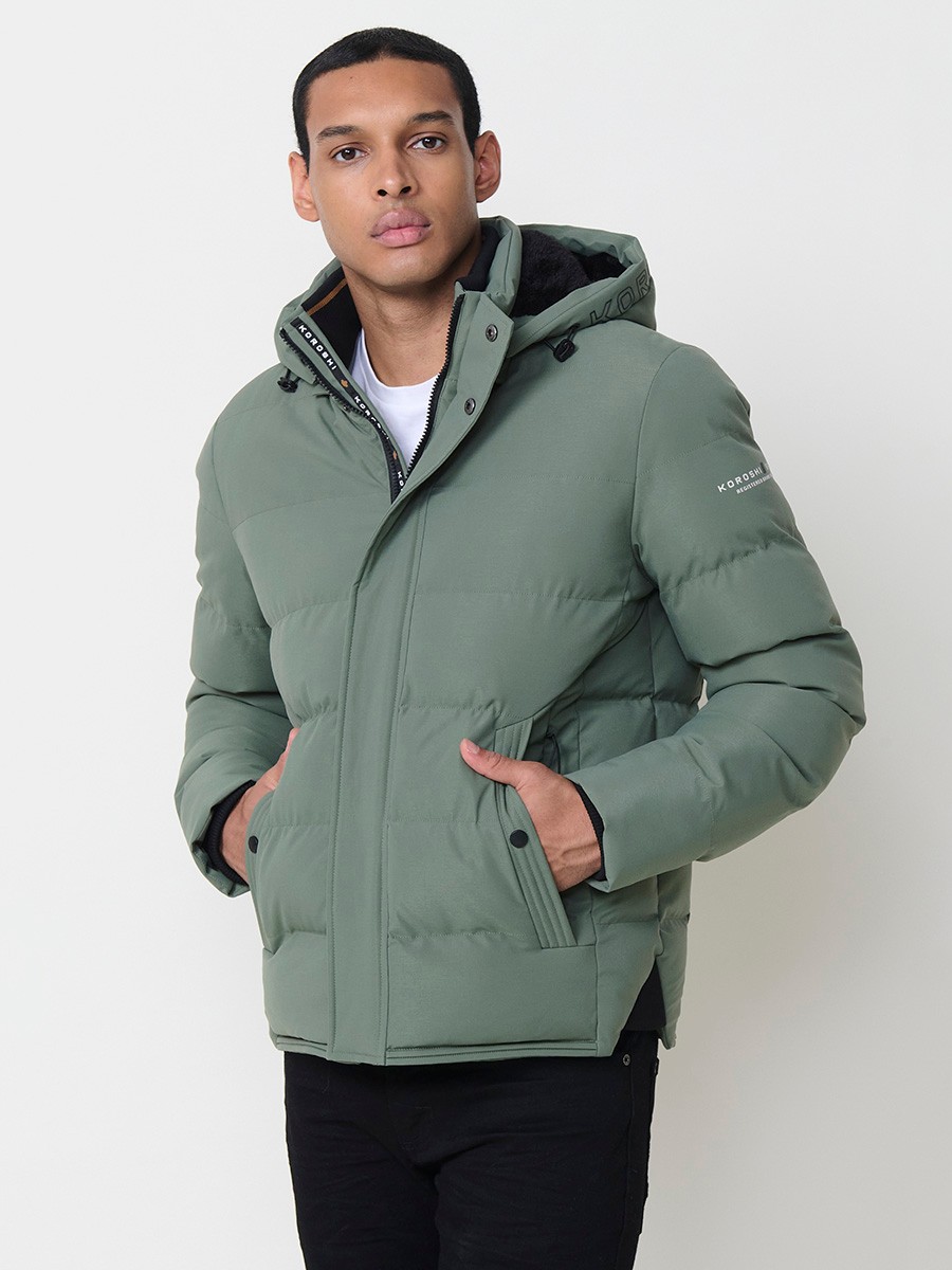 Gesteppte grüne Herrenjacke mit hohem Kragen, Kapuze, Reißverschluss und Taschen. Aus 100 % Polyester, warm, strapazierfähig und leicht.