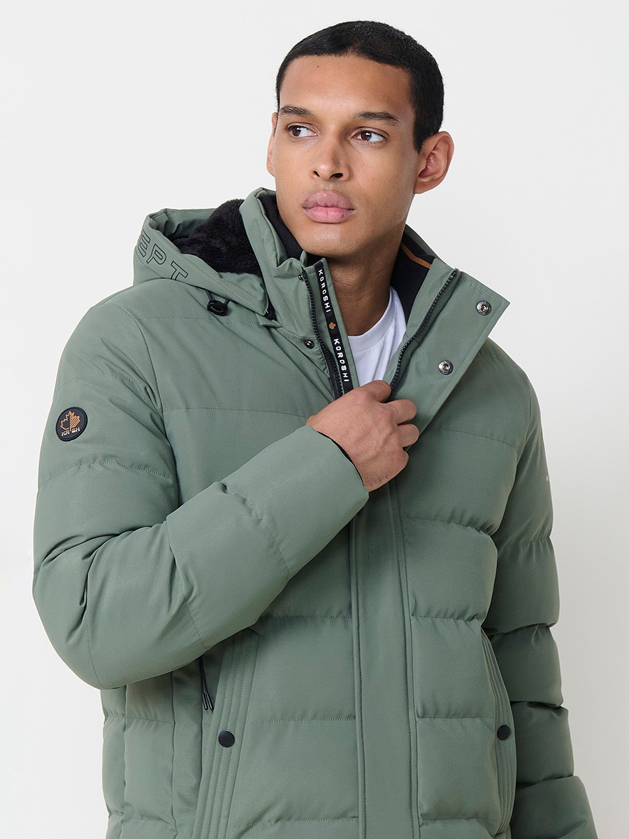 Gesteppte grüne Herrenjacke mit hohem Kragen, Kapuze, Reißverschluss und Taschen. Aus 100 % Polyester, warm, strapazierfähig und leicht.