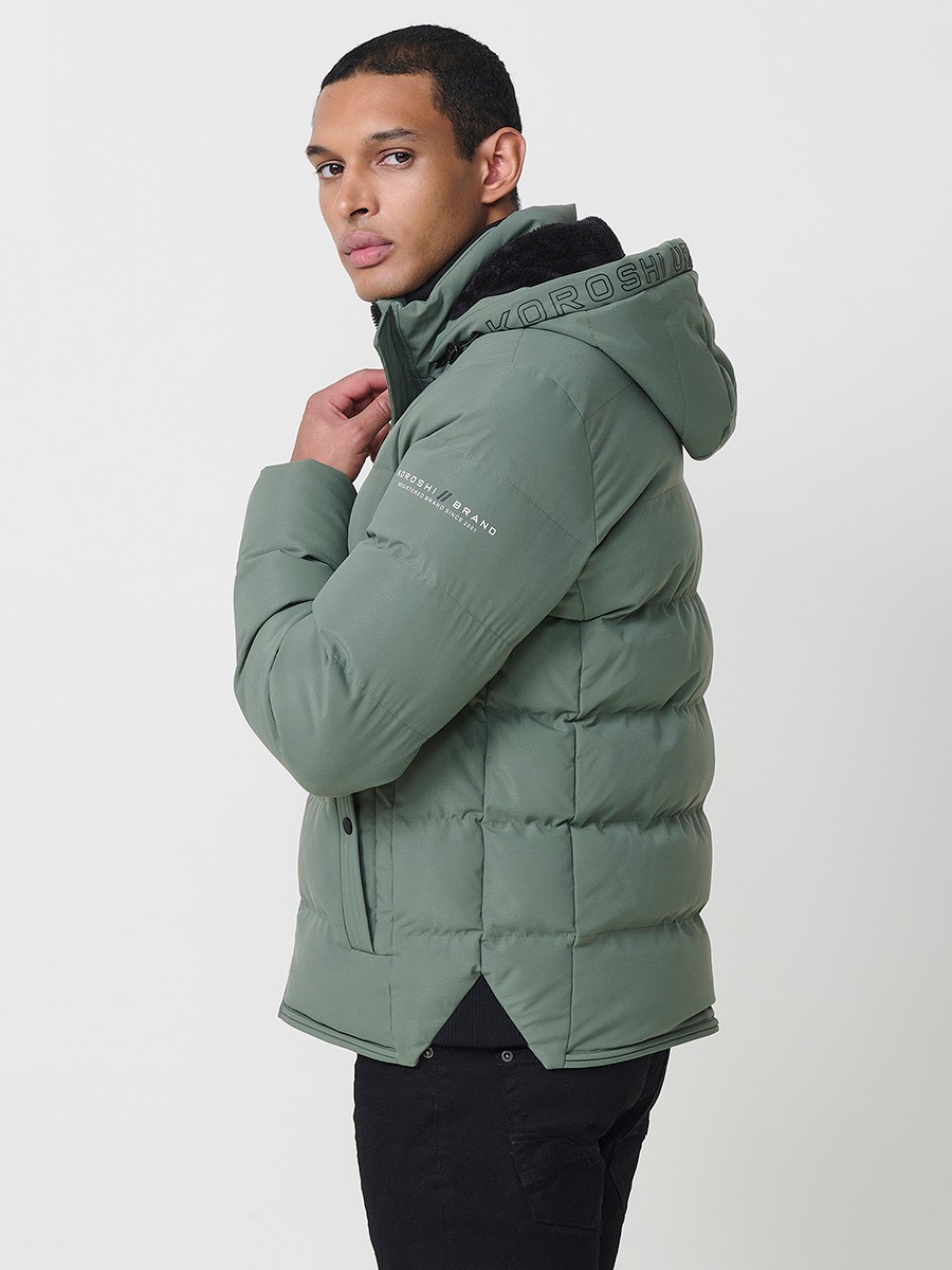Gesteppte grüne Herrenjacke mit hohem Kragen, Kapuze, Reißverschluss und Taschen. Aus 100 % Polyester, warm, strapazierfähig und leicht.