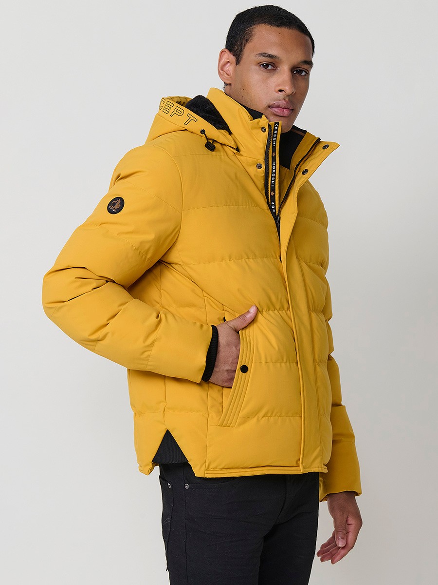 Gesteppte gelbe Herrenjacke mit hohem Kragen, Kapuze, Reißverschluss und Taschen. Aus 100 % Polyester, warm, leicht und strapazierfähig.
