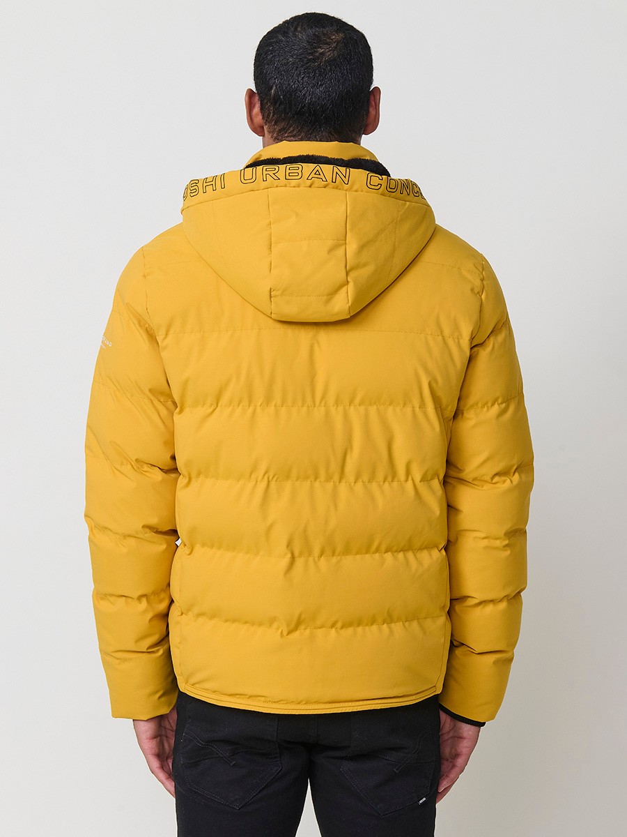 Gesteppte gelbe Herrenjacke mit hohem Kragen, Kapuze, Reißverschluss und Taschen. Aus 100 % Polyester, warm, leicht und strapazierfähig.
